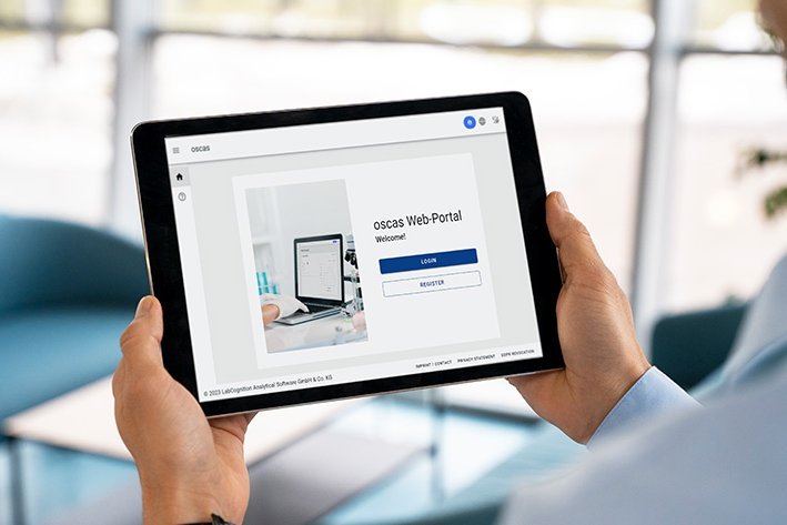 [Translate to German:] Person holding a tablet that displays the login mask of the oscas software